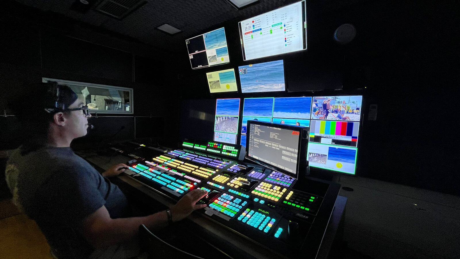 An image of a person in a production control room sitting in front of ross switchers and monitors
